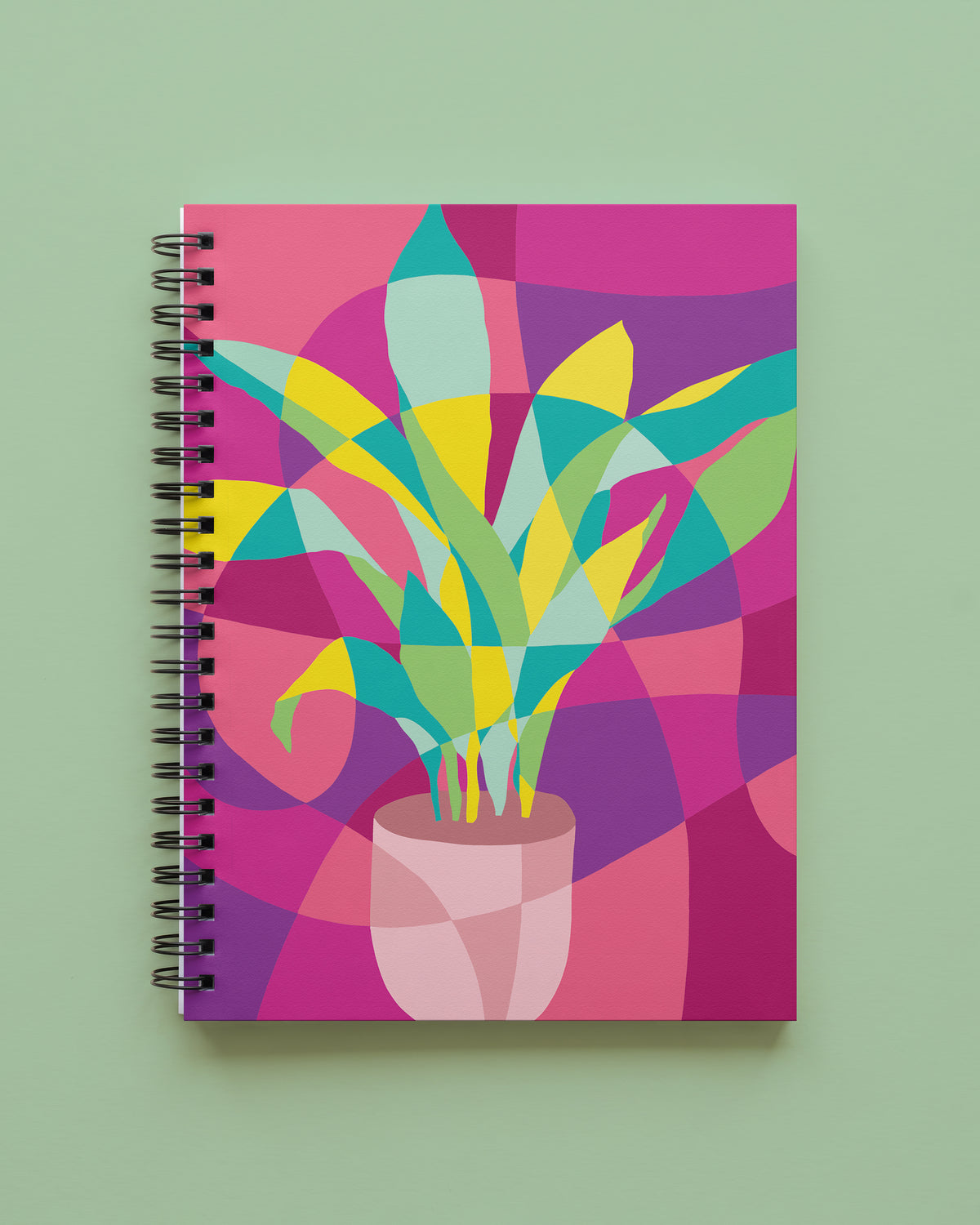 Wire bound notebook with an abstract cast iron plant in a pale pink pot, with teal, yellow, and green leaves on a magenta, purple, and coral color-block cover, shown on a sage green background